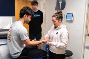 Bushnell University athletic training students practice a clinical assessment technique during a hands-on lab session.
