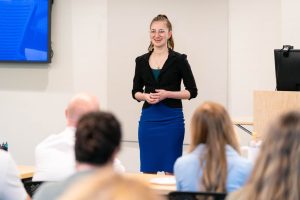 Student presenter speaks confidently to classmates and guests during a professional development presentation at Bushnell University.