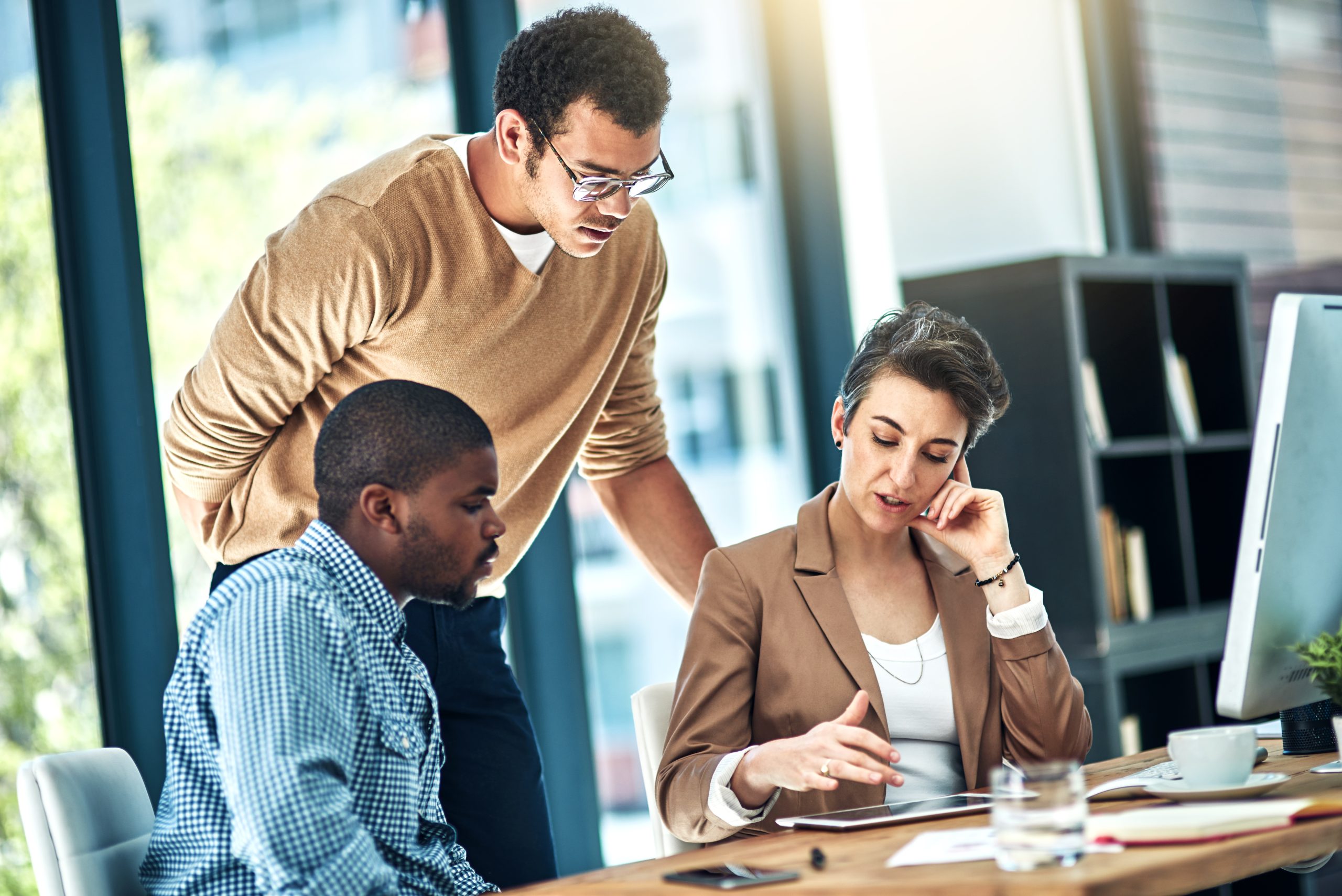 Three professionals collaborating during a business meeting.