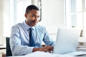 Professional working on a laptop while completing online coursework.