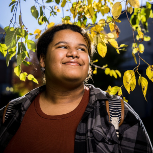 Person smiling under tree leaves and branches