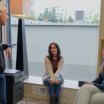 a man and two women in front of a window talking and working