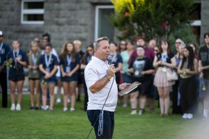 Campus pastor speaks on campus while surrounded by a group of students