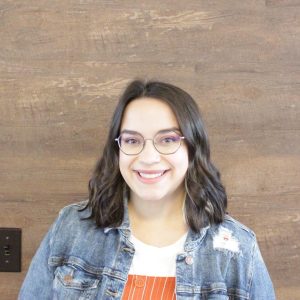 Teacher education student with glasses and black hair headshot