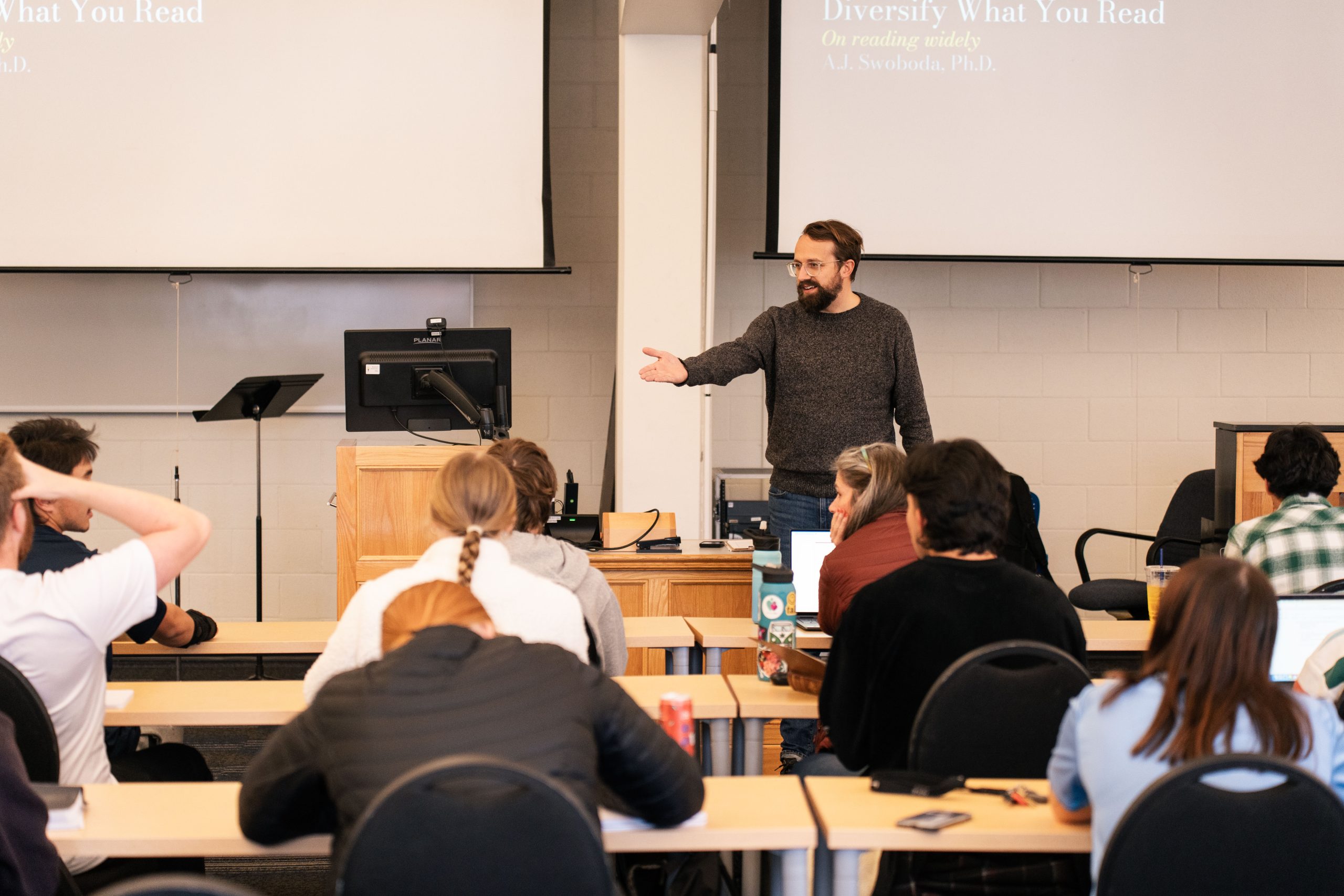 Bushnell University professor leads a classroom discussion while students listen and take notes during a lecture.