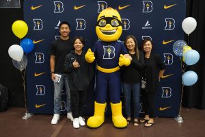 A family poses with Iggy the Beacon during a Bushnell University orientation event.