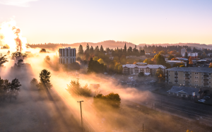 Morning fog and sunlight surround the Bushnell University campus and surrounding Eugene neighborhood at sunrise.